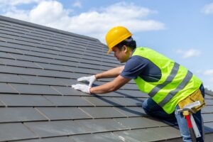worker repairing slate roof